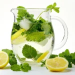 Refreshing lemon balm water infusion for weight loss, with ice and fresh leaves.